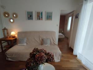 a living room with a bed with flowers on it at gite notre désir 100 m de la mer in Jullouville-les-Pins