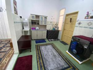 a small kitchen with a stove and a microwave at Aisy Homestay 2 in Pengkalan Cepa