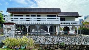 un edificio bianco con auto parcheggiate di fronte di Cozy 2BR Family Homestay in Shared Bungalow SS2 Petaling Jaya a Petaling Jaya
