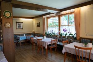 a restaurant with tables and chairs and a window at Haus Kärnten in Döbriach
