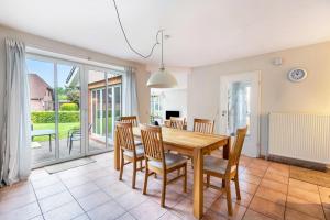 a dining room with a wooden table and chairs at Ferienhaus Sprante in Brunsbüttel