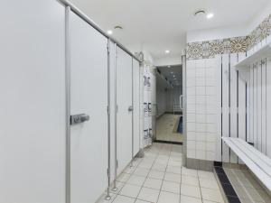 a bathroom with white tile walls and a walk in shower at Wellenkieker in Wyk auf Föhr +11 photos