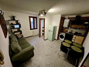 a living room with a green couch and a kitchen at Dimora di Montevenere in Monzuno