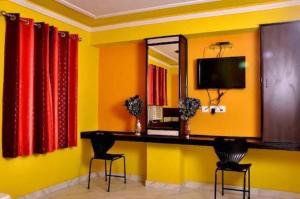 a room with a desk with two chairs and a mirror at Hotel Churu Palace in Jaipur