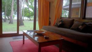 a living room with a couch and a coffee table at Barefoot Scuba Resort in Sir William Peel Island +3 photos