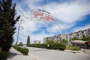 a metal arch over a street with a building at Compassrose in Mekhrably