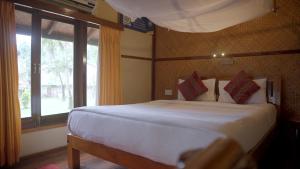 a bedroom with a bed and a large window at Barefoot Scuba Resort in Sir William Peel Island
