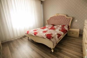 a bedroom with a bed with a red and white blanket at Compassrose in Mekhrably