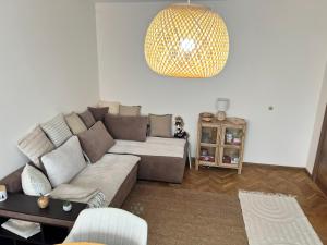 a living room with a couch and a chandelier at Lovely cozy vintage apartment in Kyustendil +4 photos
