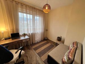 a living room with a couch and a desk with a laptop at Lovely cozy vintage apartment in Kyustendil