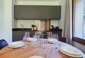 un tavolo con bicchieri e piatti da vino e una cucina di Tome, superbe appartement avec terrasse vue montagne a Champagny-en-Vanoise