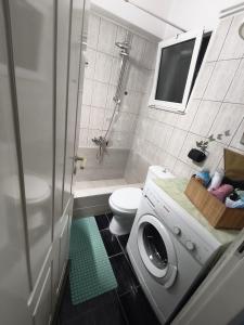 a bathroom with a toilet and a washing machine at central sweet home in Larisa