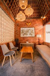 Habitación con sofá, 2 sillas y mesa. en Kuta Sekeca CoWorking Apartment Close to Kuta Beach, en Jimbaran