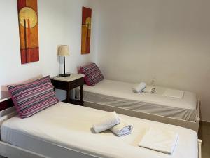 two twin beds in a room with a desk at Nikotsaras beach house since 1930 in Acharavi