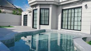 a house with a swimming pool in front of it at Jmpoolvilla in Nakhon Si Thammarat