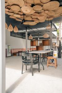 Habitación con mesa y sillas bajo el techo. en Kuta Sekeca CoWorking Apartment Close to Kuta Beach, en Jimbaran
