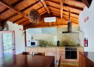 a kitchen with a table with chairs and a stove at Gerês - Aldeia Turística de Louredo in Vieira do Minho