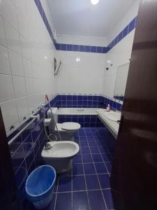 a blue and white bathroom with two toilets and a tub at Durrat Al-Arous Al-Halimah 2 in Jeddah