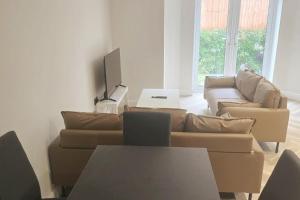 イーストボーンにあるCharming 1-Bed Retreat with Patio: Cozy & Centralのソファとテレビのあるリビングルーム