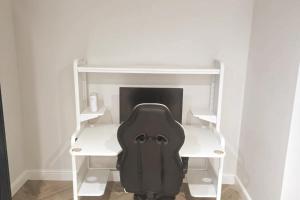 イーストボーンにあるCharming 1-Bed Retreat with Patio: Cozy & Centralの部屋の机の上に置かれた黒いオフィスチェア +3枚の写真