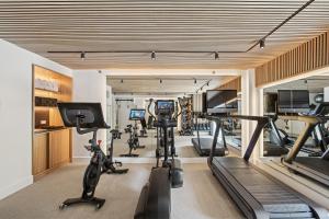 a gym with treadmills and ellipticals in a room at Hotel Park Ave NYC in New York