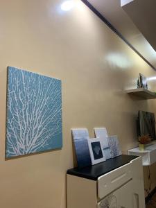 a painting on a wall next to a desk with paintings at Townhouse in Quezon City Upper Room in Manila