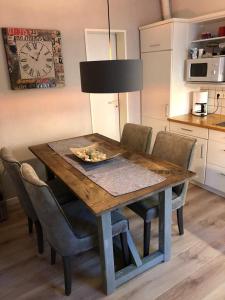 einen Esstisch mit Stühlen und eine Uhr in der Unterkunft DünenZeit in List