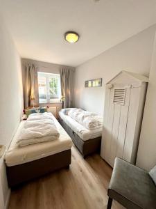 ein Schlafzimmer mit zwei Betten und einem Fenster in der Unterkunft DünenZeit in List