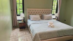 a bedroom with a bed with two towels on it at Jmpoolvilla in Nakhon Si Thammarat