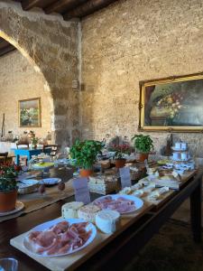 a table with meat and other food items on at Feudo Nobile in Gela