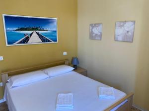a bedroom with a bed with a picture on the wall at Il Rifugio del Mare Monolocale Vasto Marina in Vasto