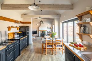 a kitchen with blue cabinets and a dining room at The Old Butchers Stores in Heacham