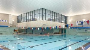 a large swimming pool with a building in the background at Beach View Apartment in West Kirby