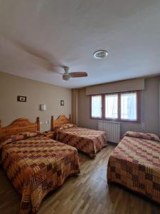 a hotel room with two beds and two windows at Hostal Valle De Tena in Sabiñánigo +48 photos