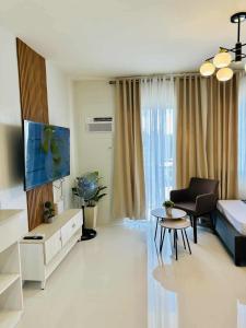 a living room with a couch and a tv at Manors Palawan Staycation in Puerto Princesa City