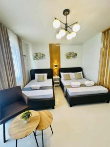 a living room with two beds and a couch at Manors Palawan Staycation in Puerto Princesa City
