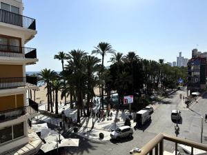 a view of a street with palm trees and a building at Paseo de la Carretera in Benidorm