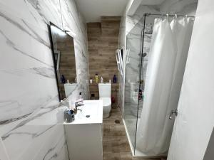 a white bathroom with a shower and a sink at Paseo de la Carretera in Benidorm +8 photos