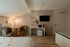 a bedroom with a bed and a desk and a tv at Hôtel Mademoiselle in Liège