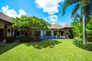 a backyard with a swimming pool and palm trees at Villa Haeata | Gorgeous 3 bedroom villa in the secured residence in Nai Harn Beach