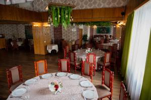 a dining room with white tables and red chairs at Hotel Dobrogea in Constanţa