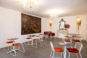 a room with tables and chairs and a painting on the wall at Hotel Palazzo Cavalieri in Siracusa +72 photos