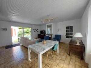 ein Esszimmer und ein Wohnzimmer mit einem Tisch in der Unterkunft Maison de pêcheur - Quartier Croix de Vie in Saint-Gilles-Croix-de-Vie