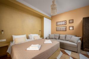 a bedroom with two beds and a couch at The Old Symi in Symi +53 photos