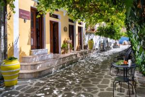 an empty street with tables and chairs on a building at The Old Symi in Symi