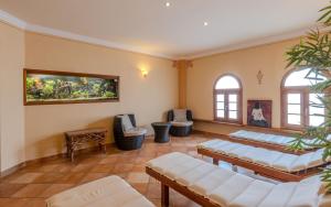 a living room with white furniture and windows at Ferienwohnungen Mäusenest in Neroth