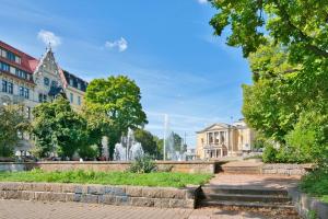 une fontaine au milieu d'une ville avec des bâtiments dans l'établissement Halle Suites by FullHouse - free parking & WiFi, à Halle-sur-Saale
