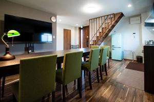 a dining room with a long table and green chairs at MusicInn Matoya - Vacation STAY 88768v in Sumoto