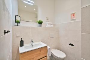 une salle de bain avec un lavabo, des toilettes et un miroir dans l'établissement Halle Suites by FullHouse - free parking & WiFi, à Halle-sur-Saale 24 autres photos