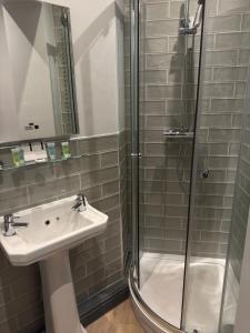 a bathroom with a sink and a shower at Red Lion Inn Wybunbury in Wybunbury
